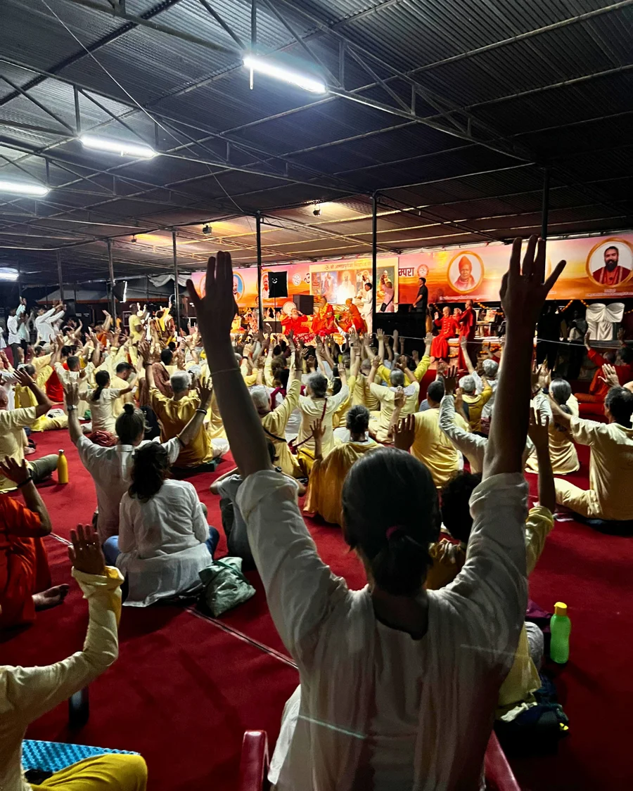 Crowd chanting Om Gurave Namah at night satsang.